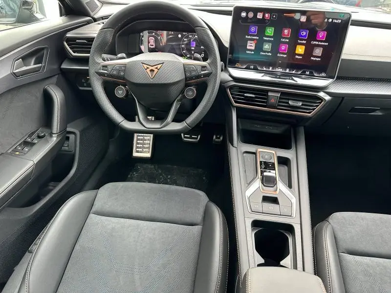 Vue intérieure de face du poste de conduite de la CUPRA Formentor 2.0 TDI avec volant sport cuir et écran tactile central.