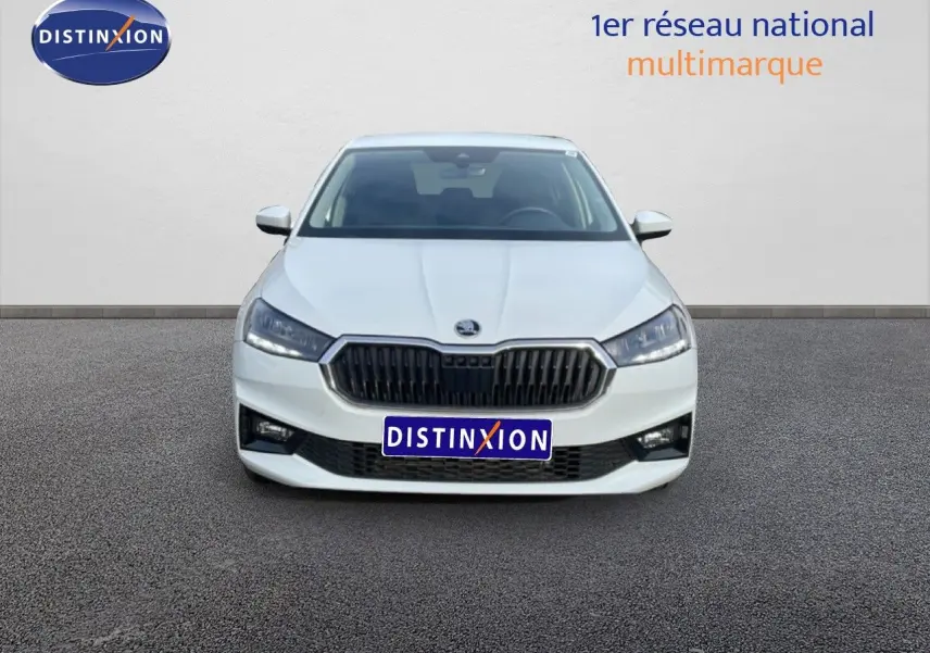 Vue frontale d'une Skoda Fabia blanche glacier 2025 avec calandre noire et phares LED allumés.