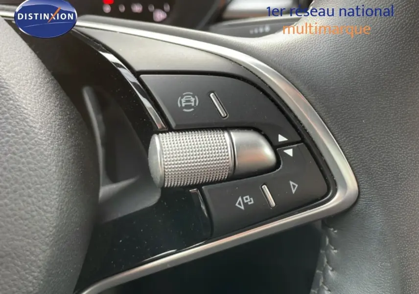 Gros plan sur les commandes multifonctions en métal brossé du volant d’une Skoda Fabia blanche Glacier 2025.