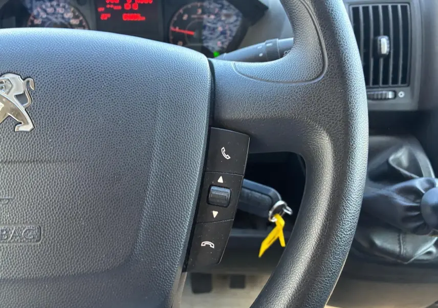 Gros plan sur le volant noir du Peugeot Boxer Cabine Approfondie 2019 avec commandes intégrées et levier de vitesses manuel visible.