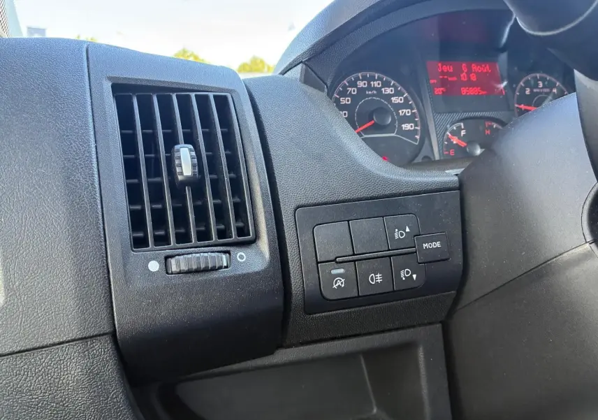 Détail intérieur côté gauche du tableau de bord gris du Peugeot Boxer cabine approfondie avec commandes d’éclairage et ventilation.