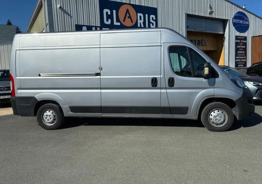 Vue de profil côté droit d’un Peugeot Boxer cabine approfondie gris 2019, avec porte latérale coulissante et jantes acier.