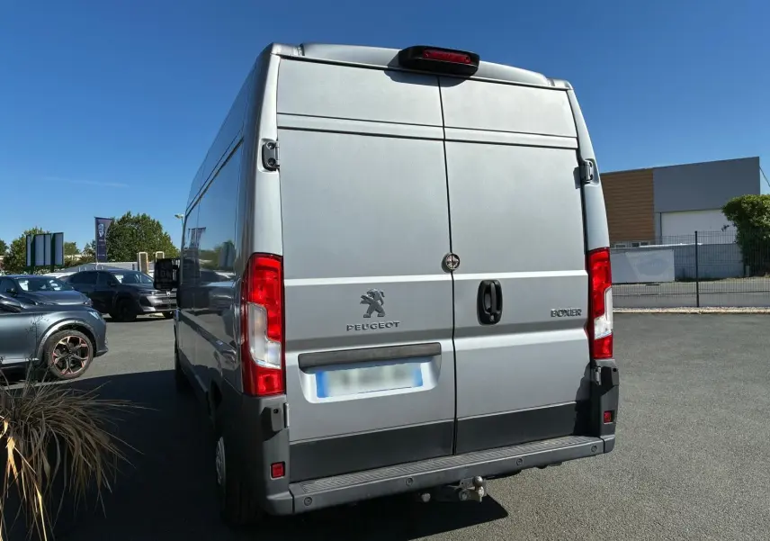 Vue arrière d'un Peugeot Boxer cabine approfondie gris 2019 avec porte double et attelage visible.