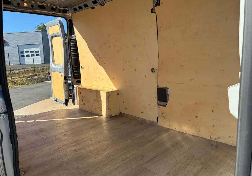 Intérieur du coffre du Peugeot Boxer gris 2019, vue depuis l'arrière droit avec portes ouvertes et revêtement bois.