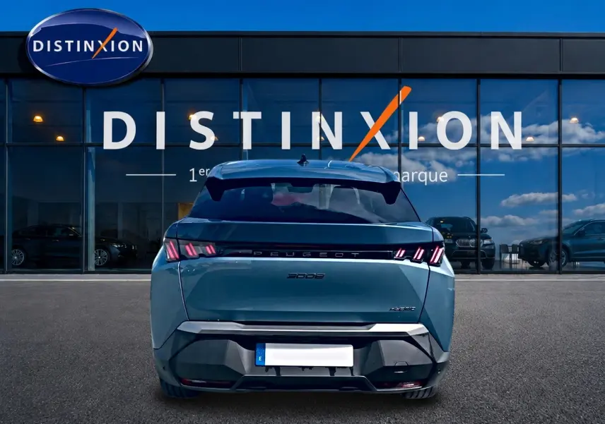Vue arrière d’un Peugeot 3008 bleu 2025 avec feux LED distinctifs, stationné devant une vitrine Distinxion.