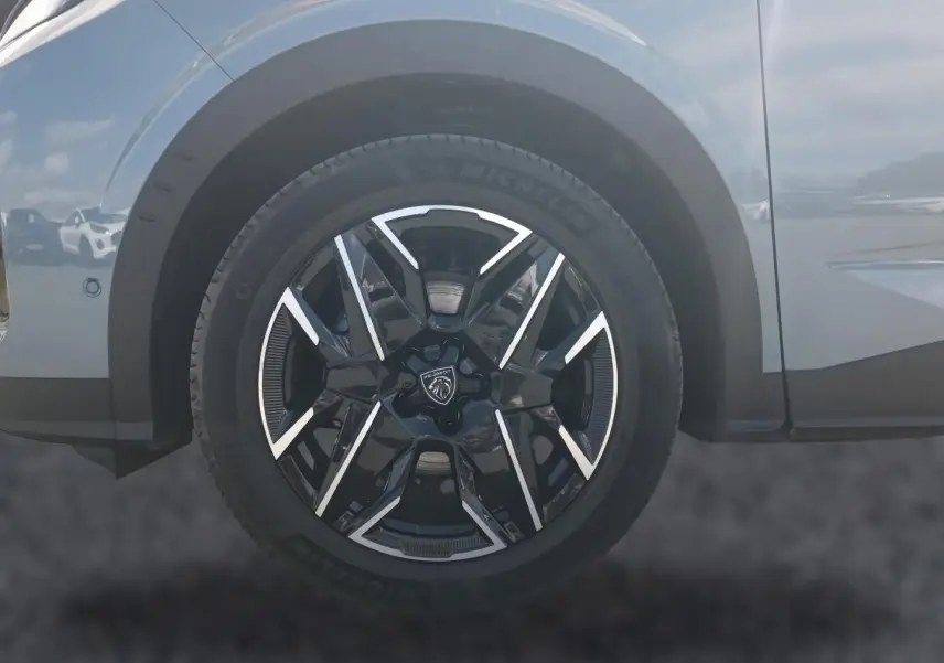 Gros plan sur la roue avant gauche noire et argentée du Peugeot 3008 bleu, avec logo lion central visible.