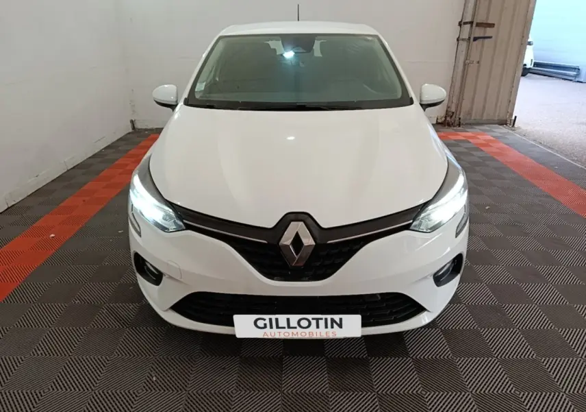 Vue avant d'une Renault Clio Business TCe 90 blanche avec phares LED allumés dans un garage.