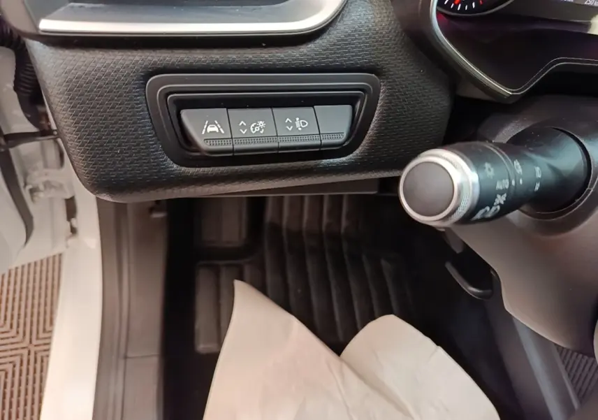 Vue intérieure côté conducteur de la Renault Clio blanche 2020, avec commandes d'assistance au volant en cuir synthétique.
