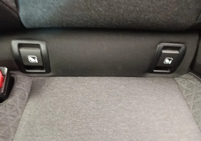 Gros plan sur la banquette arrière grise de la Renault Clio Business TCe 90 avec commandes de rabattement visibles.