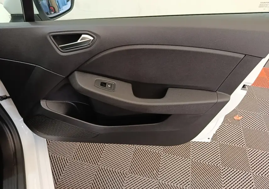 Vue rapprochée de la porte avant gauche blanche d'une Renault Clio 2020, avec panneau intérieur noir et commande de vitre.