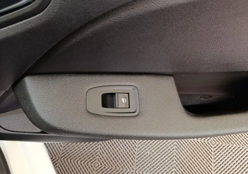 Gros plan sur l'interrupteur de verrouillage des portes côté intérieur d'une Renault Clio Business blanche.
