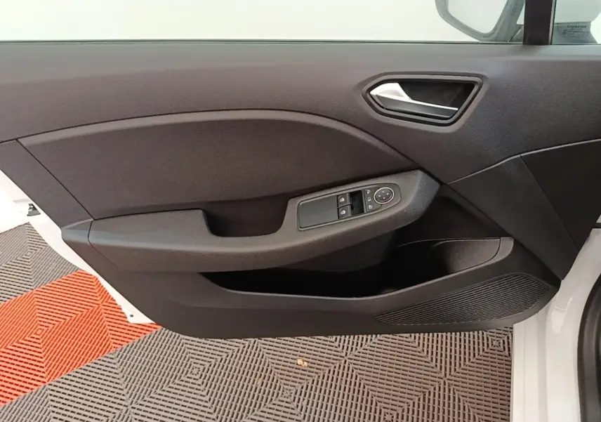 Vue rapprochée de la porte avant gauche blanche de la Renault Clio 2020 avec commandes électriques des vitres et poignée intégrée.
