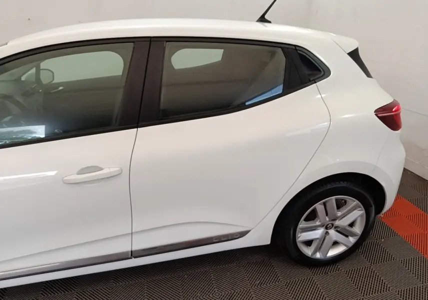 Vue latérale droite d'une Renault Clio blanche 2020 avec jantes alliage et logo Clio sur la bas de caisse.