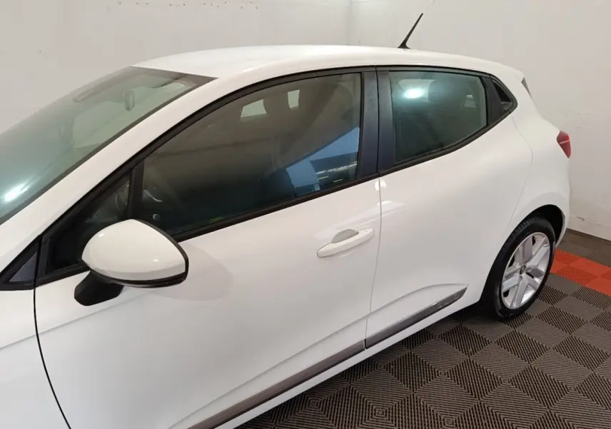 Vue latérale côté gauche d'une Renault Clio Business blanche, mettant en valeur la ligne épurée et les rétroviseurs assortis.