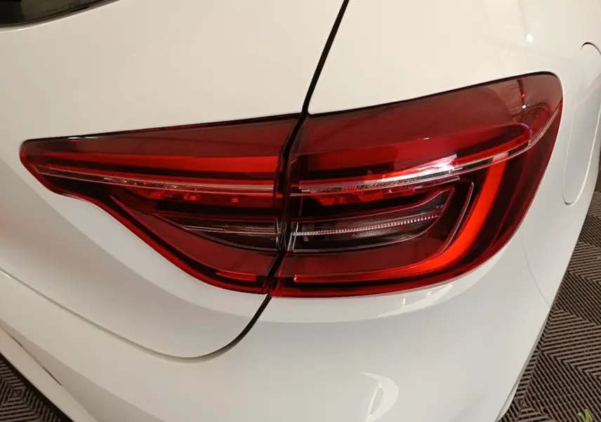 Gros plan sur le feu arrière droit rouge d’une Renault Clio Business TCe 90 blanche de 2020.