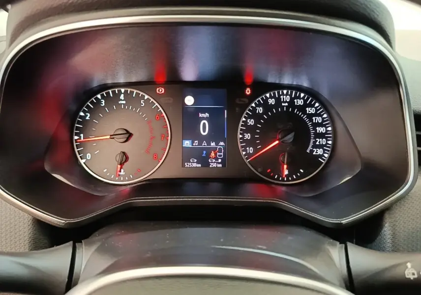 Vue rapprochée du tableau de bord de la Renault Clio blanche, affichant le compteur de vitesse et le compte-tours.
