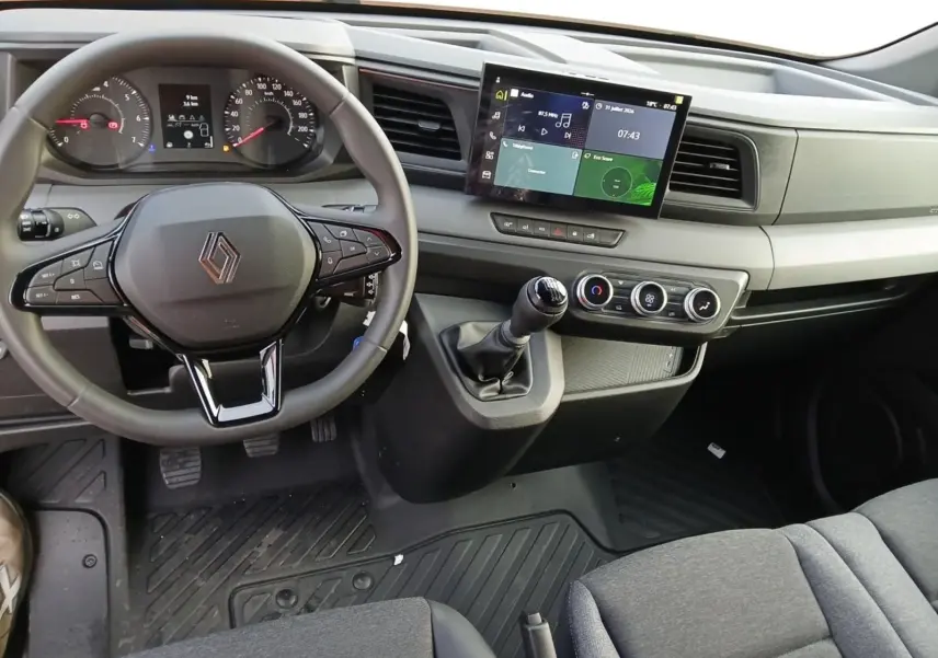 Vue intérieure avant du tableau de bord du Renault Master L2H2 2026, volant multifonction et écran tactile central visibles.