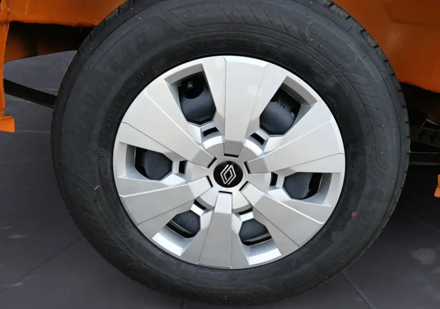 Gros plan sur la roue avant gauche du Renault Master orange, mettant en valeur la jante argentée au design moderne.