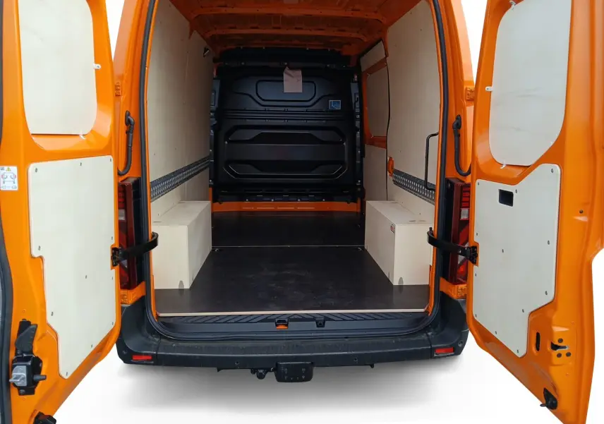 Vue arrière des portes ouvertes du Renault Master orange, montrant l'intérieur spacieux avec habillage bois et plancher noir.