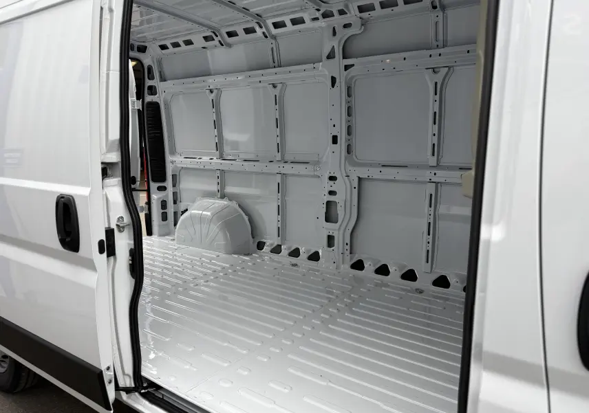 Vue intérieure côté droit du fourgon blanc Citroën Jumper L3H2 2025, montrant l’espace de chargement vide et métallique.