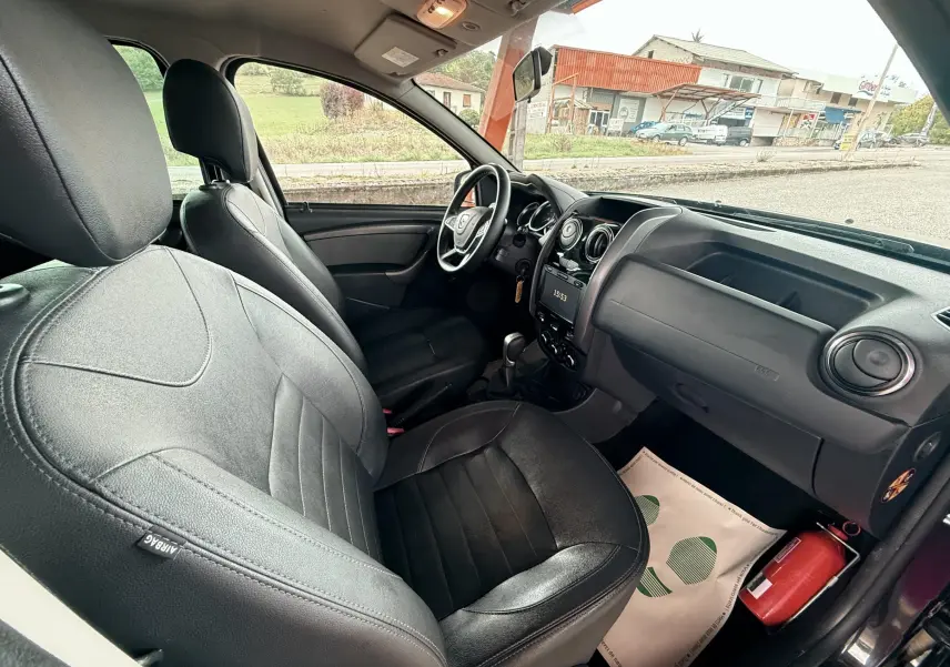 Vue intérieure côté conducteur du Dacia Duster 2017 noir métal, sièges cuir noir et tableau de bord avec écran tactile.