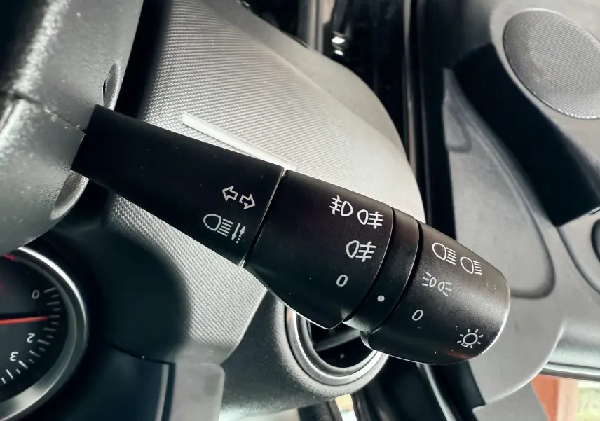 Gros plan sur la commande des feux et clignotants à gauche du volant du Dacia Duster noir métal 2017.