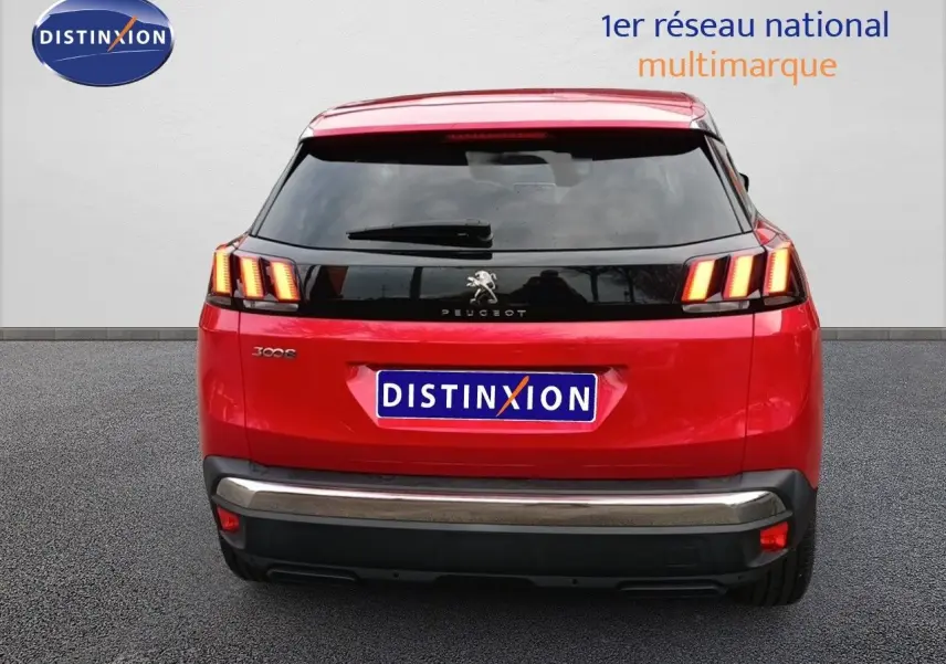 Vue arrière d'un Peugeot 3008 rouge foncé métallisé avec feux arrière allumés et logo lion visible.