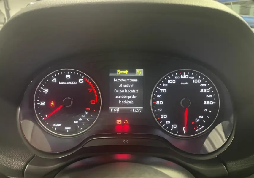 Vue rapprochée du tableau de bord numérique d’un Audi Q2 1.5 TFSI 2023, affichage moteur en marche.