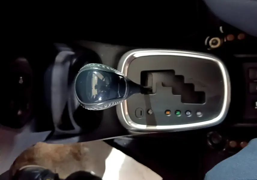 Vue rapprochée du levier de vitesses automatique de la Toyota Yaris 1.5 VVT-I Hybrid France Business, entouré d'un cadre chromé.