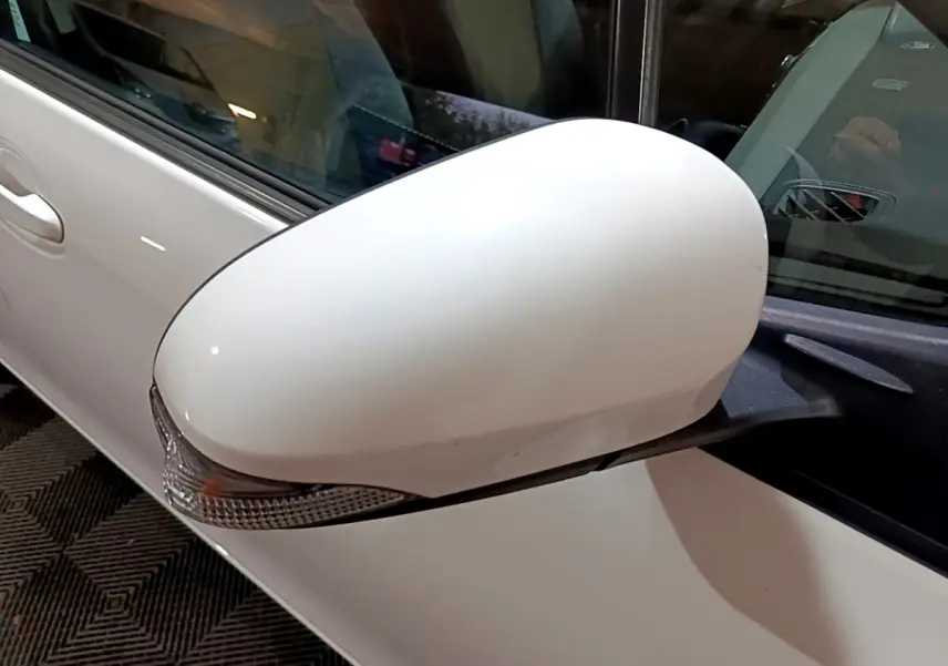 Gros plan sur le rétroviseur droit blanc de la Toyota Yaris 1.5 VVT-I HYBRID France Business 2019.