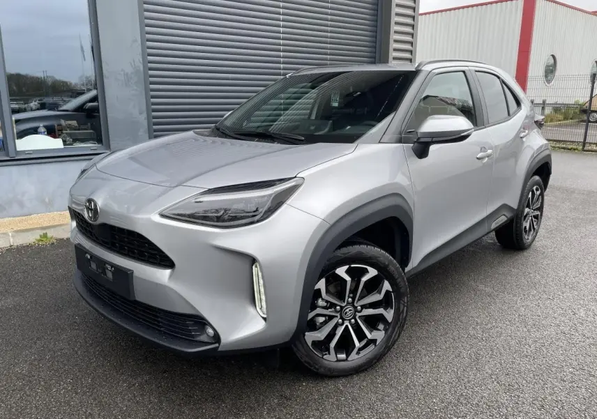 Toyota Yaris Cross gris clair vue 3/4 avant droit, avec toit noir et jantes alliage distinctives.
