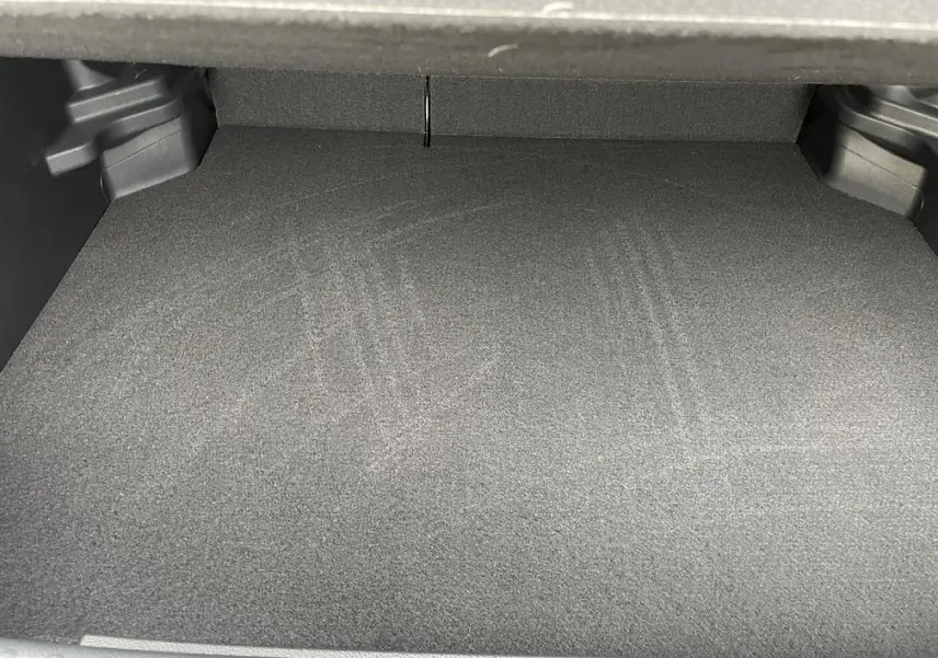 Coffre vide de la Toyota Yaris Cross 1.5 Hybrid 130h Design en gris clair, vue intérieure depuis l'arrière.