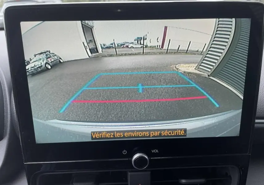 Affichage de la caméra de recul d'une Toyota Yaris Cross gris clair, avec lignes de guidage bleues et rouges visibles.