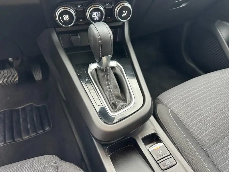 Gros plan sur la console centrale du Renault Arkana 2025 montrant le levier de vitesse automatique et les commandes de climatisation.