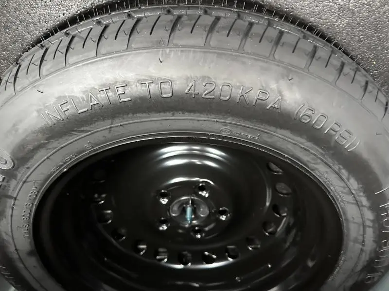 Gros plan sur la roue de secours noire d’un Renault Arkana 2025, mettant en valeur le pneu avec indication de pression.
