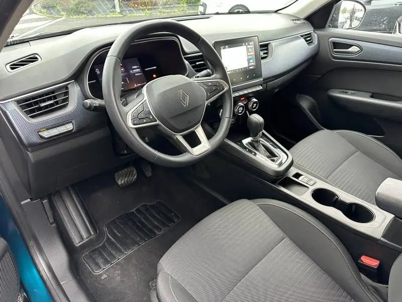 Intérieur côté conducteur du Renault Arkana 2025 bleu Zanzibar, tableau de bord moderne avec écran tactile et volant multifonction.