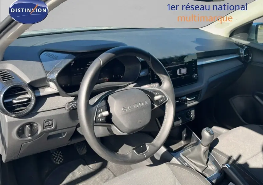 Vue intérieure côté conducteur du tableau de bord et volant noir d'une Skoda Fabia 2025 en tissu gris.