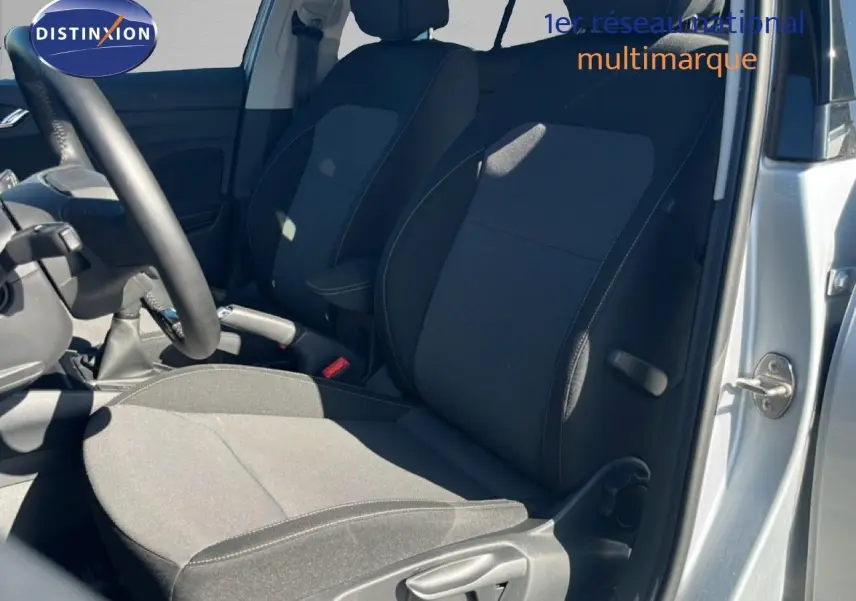 Vue intérieure côté conducteur de la Skoda Fabia 2025 en Reflex Silver, sièges tissu gris foncé avec surpiqûres contrastées.