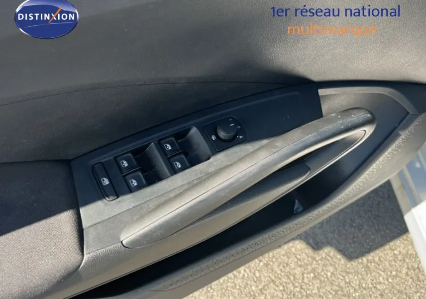 Gros plan sur la commande des vitres électriques côté conducteur d'une Skoda Fabia 2025 couleur argent Reflex Silver Metal.