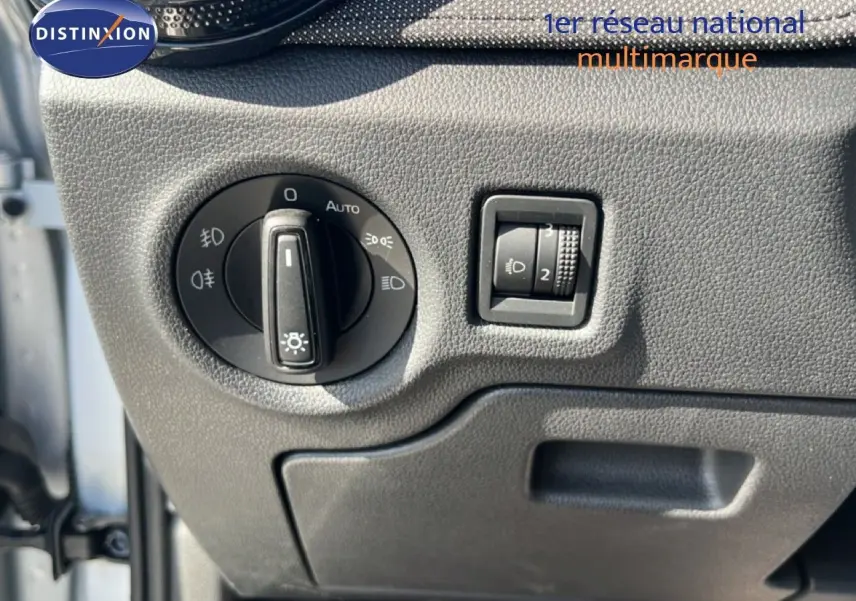 Détail du panneau de commande des phares sur la gauche du tableau de bord gris noir d'une Skoda Fabia 2025 Reflex Silver.