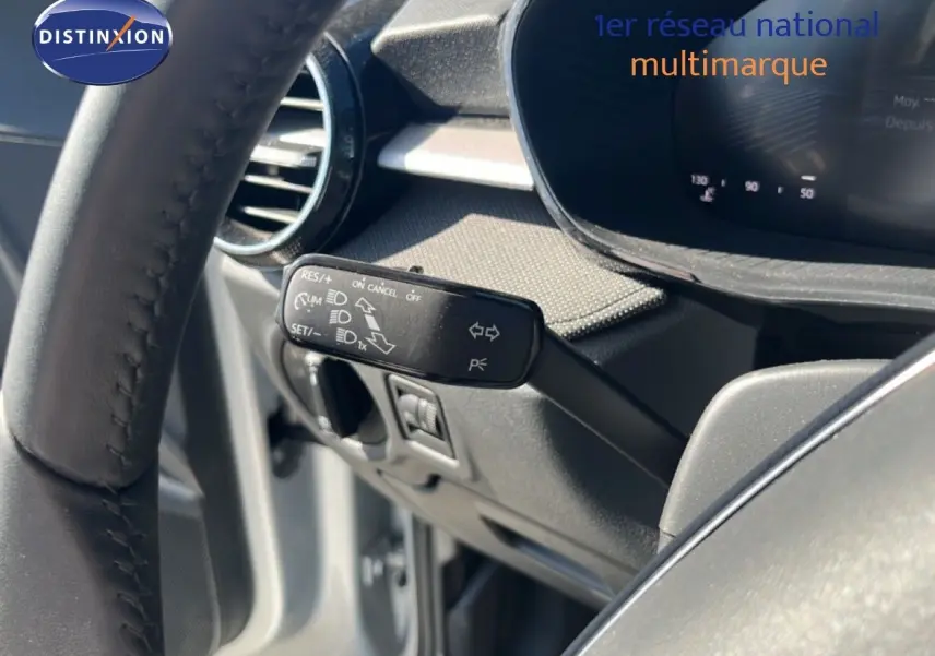 Gros plan sur la commande de régulateur de vitesse à gauche du volant d’une Skoda Fabia 2025 gris argent Reflex Silver.