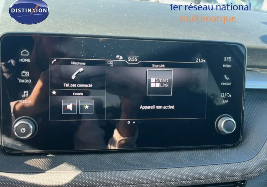 Écran tactile central de la Skoda Fabia 2025 affichant SmartLink, avec tableau de bord gris et reflets lumineux.