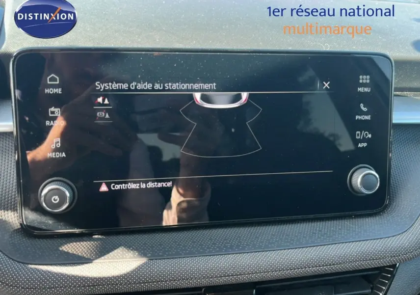 Écran tactile du système d'aide au stationnement de la Skoda Fabia 2025 en gros plan, tableau de bord noir.