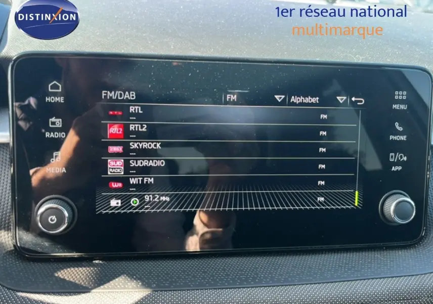Écran tactile central de la Skoda Fabia 2025 affichant les stations radio FM, avec commandes physiques sur les côtés.
