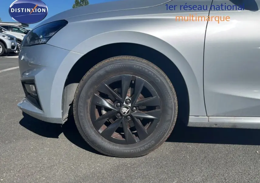 Gros plan sur la roue avant gauche noire d'une Skoda Fabia 2025 en Reflex Silver Metal, avec jante noire distinctive.