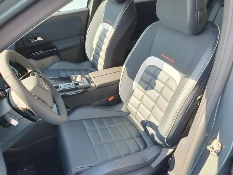 Vue intérieure côté conducteur du Citroën C5 Aircross 2026 avec sièges en tissu bleu et accoudoir central.