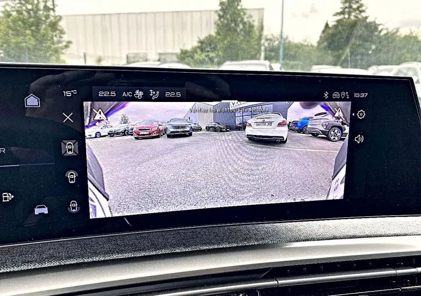 Écran tactile intérieur montrant la caméra de recul du Peugeot 3008 bleu, vue arrière du véhicule en stationnement.