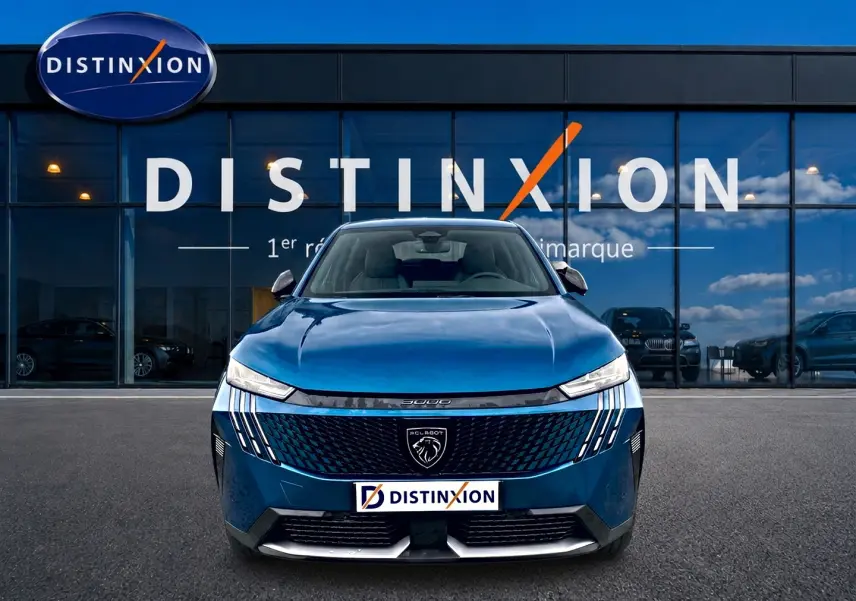 Vue avant d’un Peugeot 3008 bleu 2025 avec calandre noire et phares LED, devant une vitrine Distinxion.