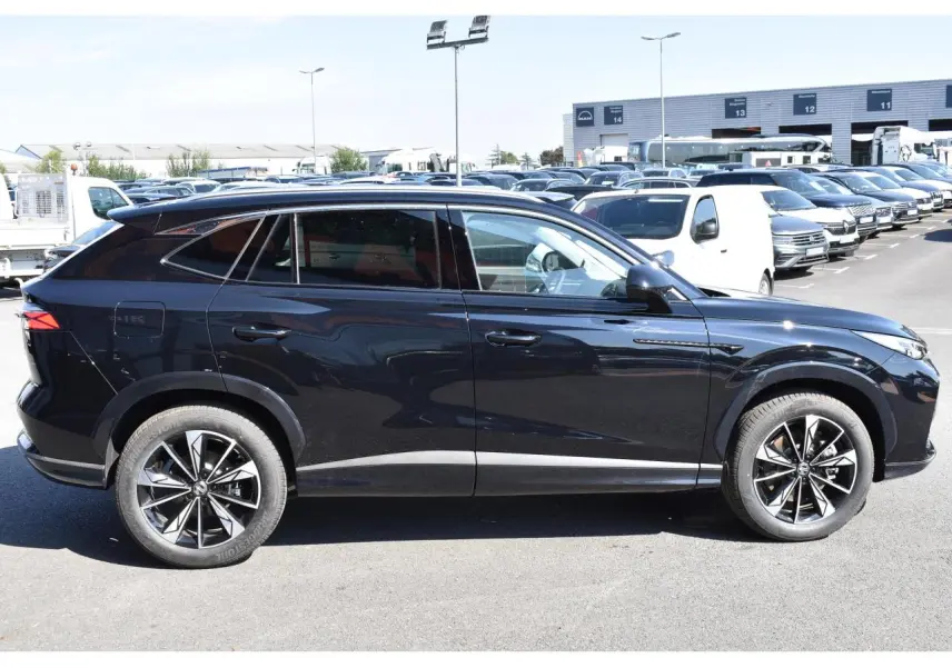 Vue de profil côté gauche du SUV MG EHS 1.5 Hybrid+ noir avec jantes alliage 19 pouces et vitres surteintées.