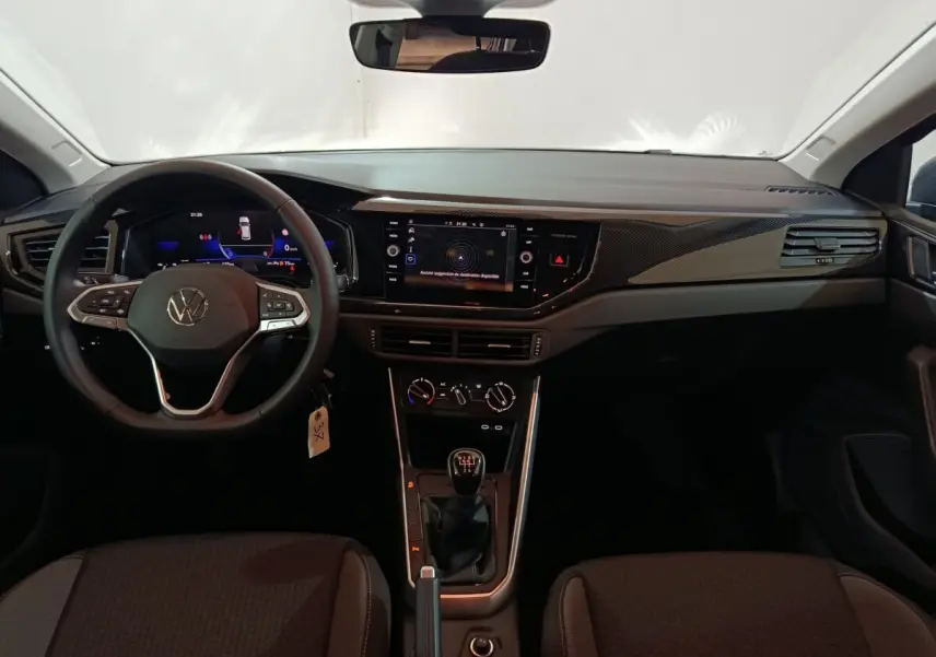 Vue intérieure frontale du tableau de bord et volant cuir de la Volkswagen Polo gris foncé avec écran tactile 8 pouces.